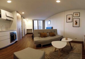 A modern living space with a kitchen, sofa, and dining area. - Modern Studio Apartment (Bogotá)