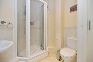 Ein Badezimmer mit Duschkabine, Toilette und Waschbecken.
