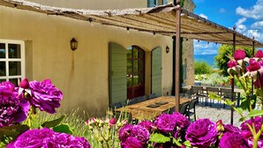 Una casa con un patio, una mesa y sillas.