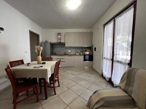 Ein kompakter Wohnbereich mit Essplatz, Küchenzeile und Sofa.
