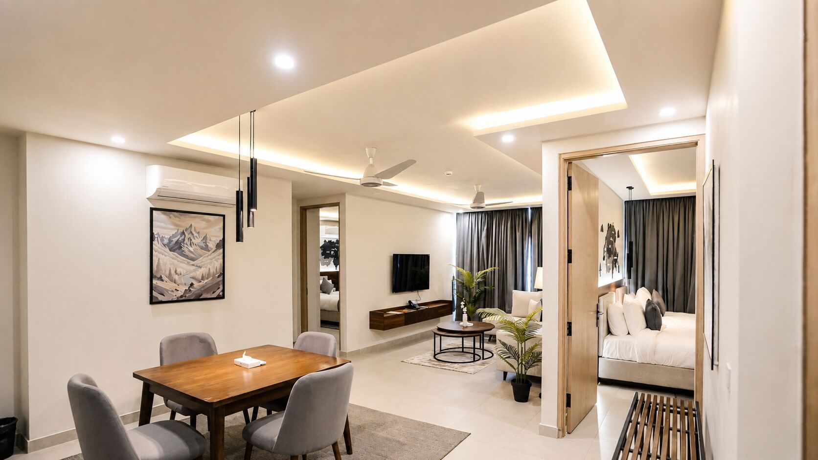 Un salon moderne comprenant un coin repas, un canapé, un téléviseur et un tableau accroché au mur.