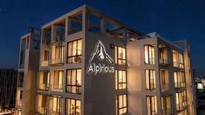 Ein mehrstöckiges Hotel mit auffälligem Logo an der Fassade, großen Fenstern und Balkonen.
