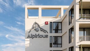 A building with a mountain logo and the name 'Alpirious' on the facade.