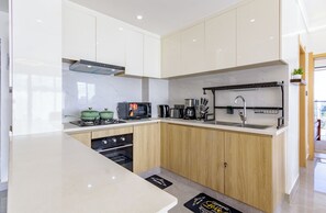 Eine moderne Küche mit weißen Schränken, einem Backofen und einer Kaffeemaschine.