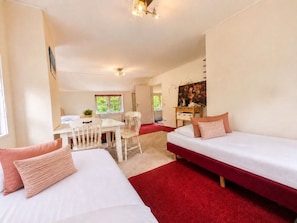 Ein Hotelzimmer mit zwei Betten, einem Esstisch und einem Stuhl.