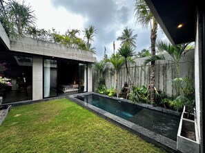 A modern house with a swimming pool, a grassy lawn, and tropical plants. - Seseh House by Alfred in Bali (Cemagi)
