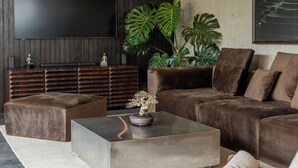 A modern living room with a sofa, ottoman, and a coffee table. - Seseh House by Alfred in Bali (Cemagi)