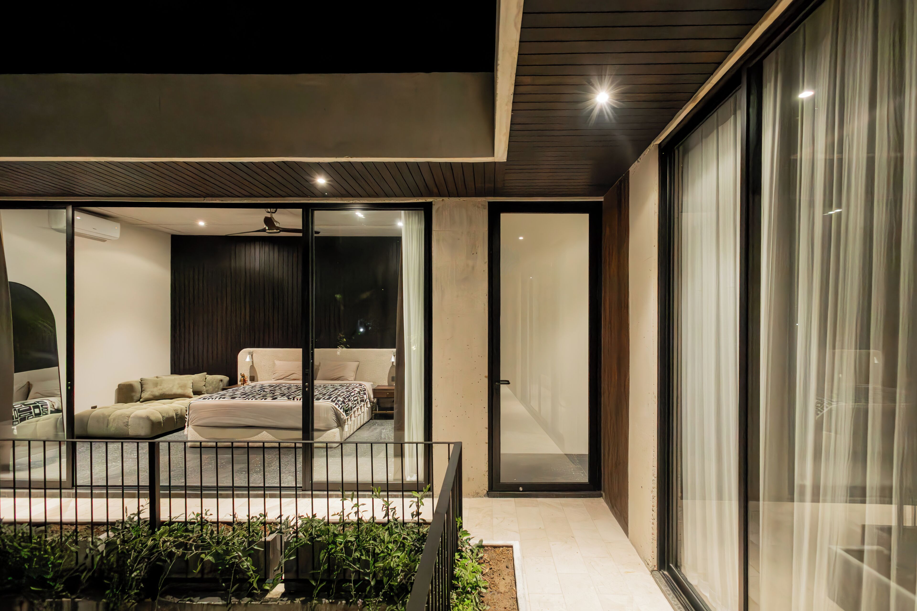 A modern bedroom with a bed, bedside table, and a window.