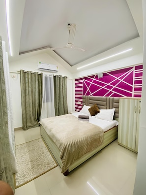 A bedroom with a bed, an air conditioning unit, a ceiling fan, and a wardrobe.