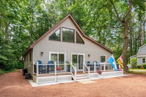Eine eingeschossige Holzhütte mit Veranda, großen Fenstern und einer Flagge.