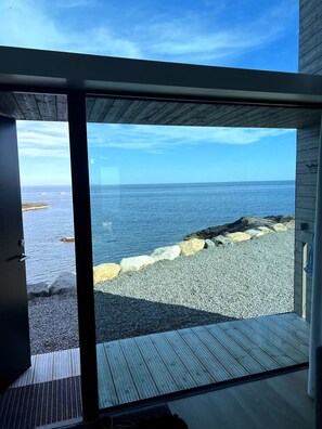 Un interior moderno con un amplio ventanal que da a una vista de la playa.