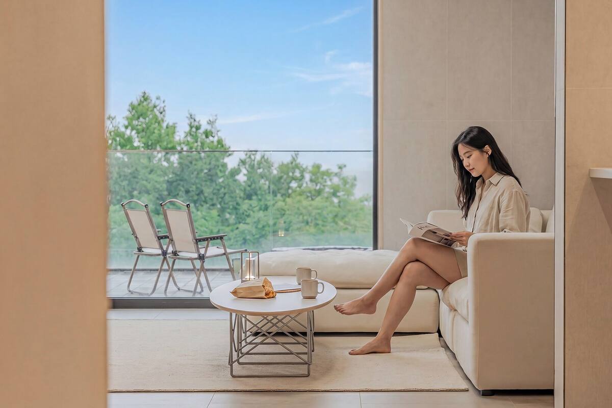 A modern interior with a sofa, a round table, and two chairs.
