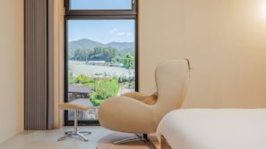 A hotel room with a large window, a single bed, a chair, and a small table. - Chuncheon Stay Moon (Chuncheon)