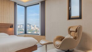 A hotel room with a large window, a bed, a chair, and a framed picture on the wall. - Chuncheon Stay Moon (Chuncheon)