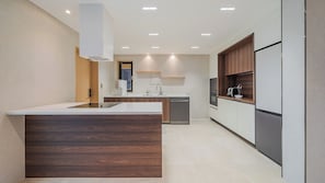 Una cocina moderna con una isla central, horno integrado y lavavajillas.