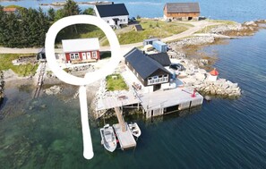 A coastal property with a dock, a small boat, and a lighthouse.