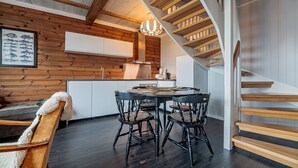 Una cocina moderna con paredes de madera, una mesa redonda para comer y una escalera.