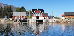 Une propriété située au bord de l’eau, dotée d’un quai, d’une maison rouge et d’un phare.