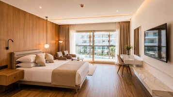 Habitación de hotel moderna con una cama grande, un escritorio y vistas a una piscina y edificios.