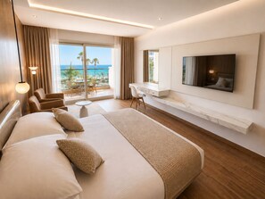 A hotel room with a large bed, a desk, a TV, and a balcony with a view of the ocean. - Amarina Sapphire Beach Hurghada Hotel - Couples & Adults Only (Hurghada)