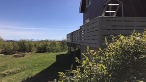 Ett tvåvåningshus med en inglasad veranda och utsikt över landskapet.