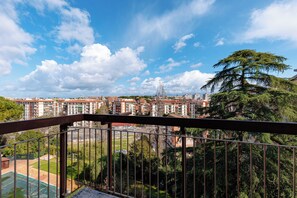 Ein Balkon mit Blick auf ein Wohngebiet, einschließlich Gebäude und Bäume.