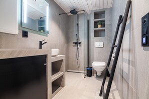 Un baño moderno con ducha, inodoro y lavamanos.