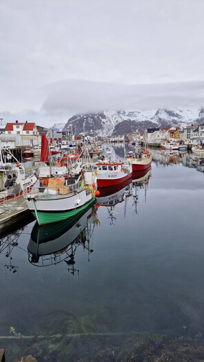 Un port où des bateaux sont amarrés, avec une eau calme et des bâtiments en arrière-plan.