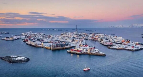 Un pueblo costero con numerosos muelles y barcos, rodeado de agua.