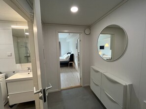 Un bany modern amb un lavabo, un mirall i una dutxa.