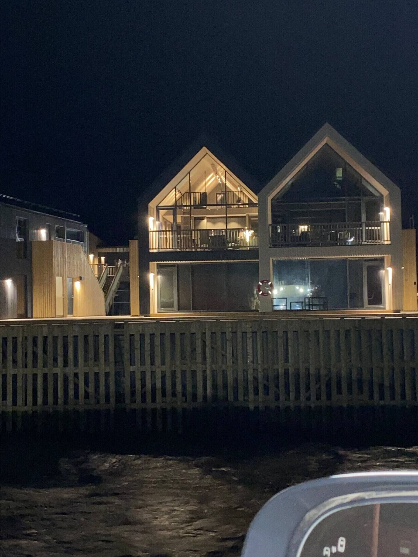 Un bâtiment à deux étages doté d’un balcon à l’étage supérieur, d’un escalier menant à l’étage supérieur et d’une clôture en bois au premier plan.