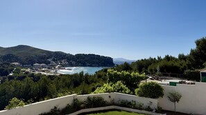 A coastal view with a hillside, a clear sky, and a building with outdoor seating. - Apartment with ocean view, sleeps 8 - Les Restanques (Carry-le-Rouet)