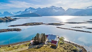 Una cabaña aislada con vistas a un lago tranquilo y montañas.