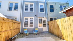 A residential building with a grey facade, white window frames, and a wooden fence. - Spacious Newly Renovated Scenic Bay View Home Sleeps 1-8, Free Parking very safe (Ventnor City)