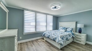 A bedroom with a bed, nightstands, a lamp, and a window with blinds. - Spacious Newly Renovated Scenic Bay View Home Sleeps 1-8, Free Parking very safe (Ventnor City)