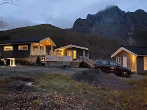Une rangée de cabanes avec une chaîne de montagnes en arrière-plan.