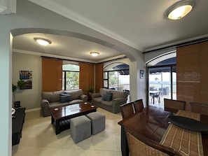 A spacious living area with a sofa set, a coffee table, and a dining table with chairs. - Beachfront Luxury 7 Chaka's Place Ballito (Ballito)