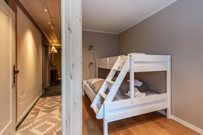Une pièce avec un lit superposé, un couloir et un escalier.