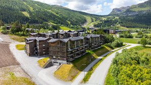 A modern hotel with multiple floors, a central courtyard, and a view of the surrounding mountainous landscape. - Hemsedal ski in/ski out – new apartment with everything you need (Hemsedal)