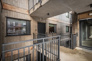 Ein modernes Gebäude mit Holzverkleidung, Metallgeländer und Glastür.