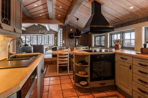 A kitchen with wooden cabinets, a central island, a built-in oven, and a large window.