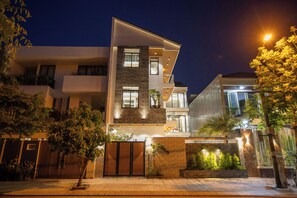 Un moderno edificio residenziale a più piani con ingresso chiuso da cancello, balconi ben visibili e una facciata luminosa.