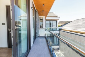 Ein modernes Gebäude mit Glasgalerie, Holzboden und Blick auf benachbarte Häuser.