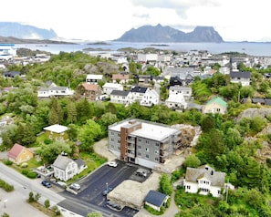 An aerial view of a residential area with houses, a parking lot, and a road. - Studio Vestermyrveien, Svolvær (Vågan)