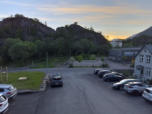 A parking lot with cars, a building, and a mountainous backdrop. - Studio Vestermyrveien, Svolvær (Vågan)