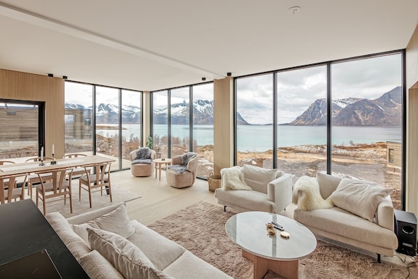 A modern living room with a large window overlooking a mountainous landscape.