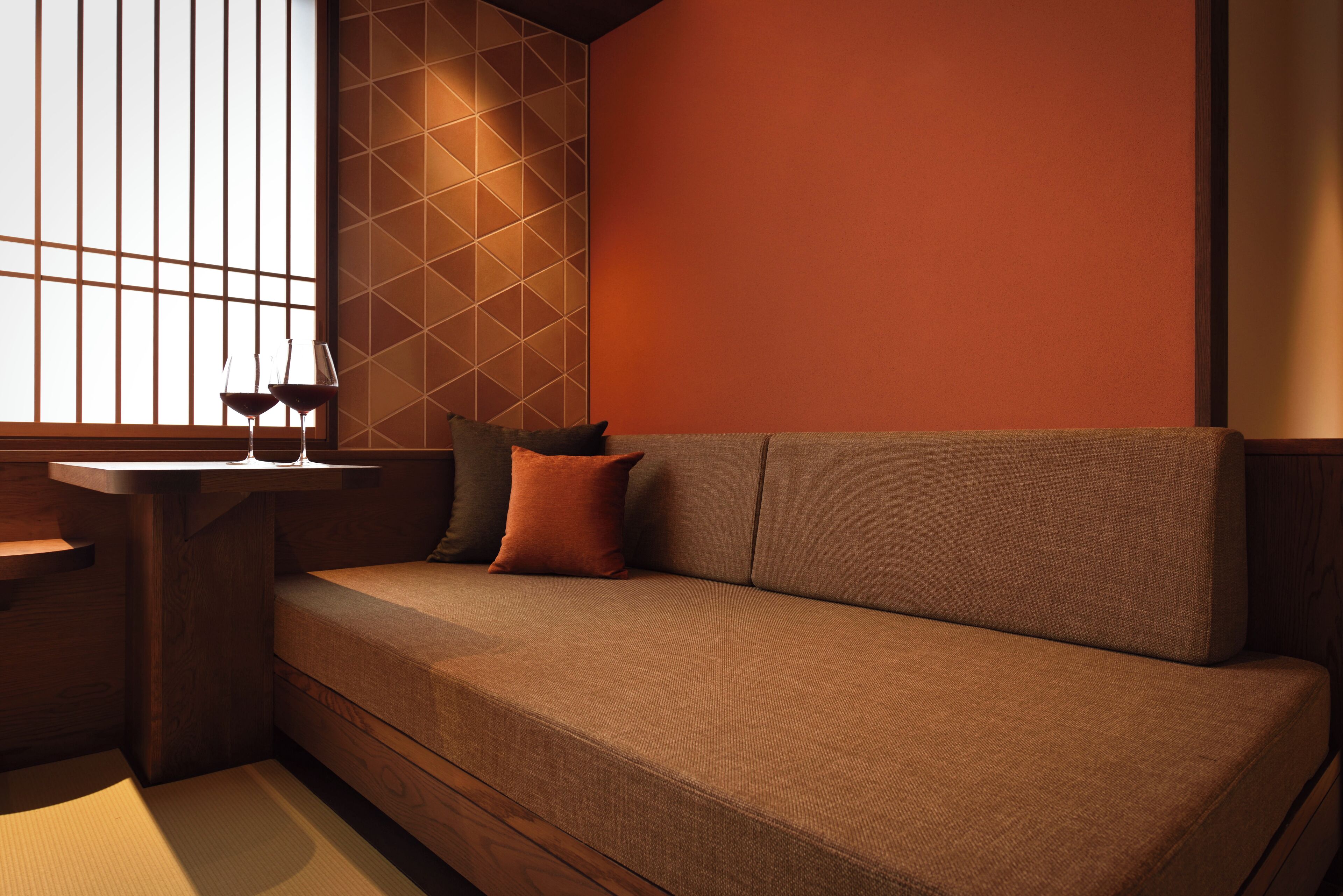 A modern interior with a sofa, a table, and a window with vertical blinds.