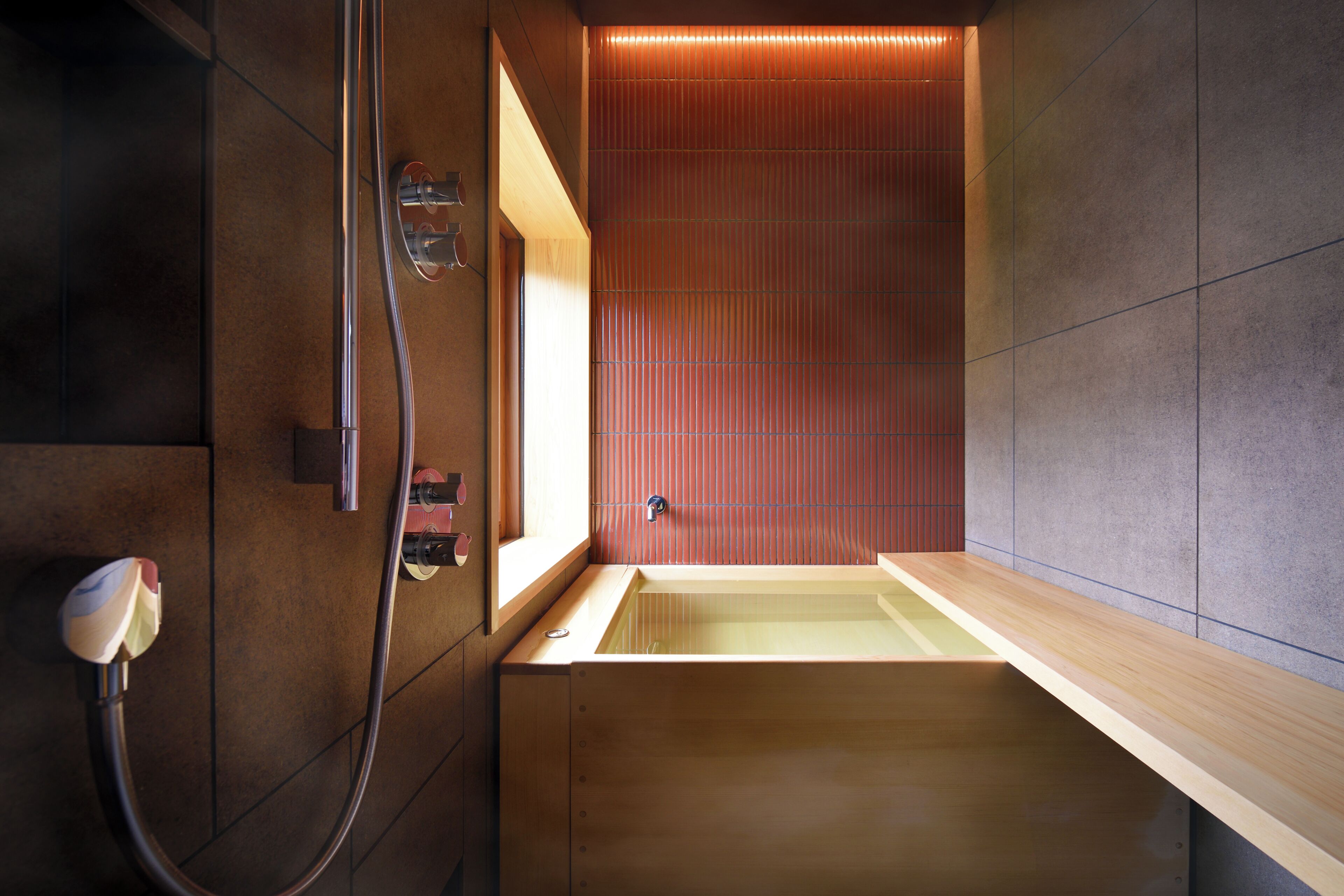 Un baño moderno con una bañera de madera, zona de ducha y un perchero de pared.