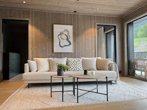 A modern living room with a sofa, a coffee table, and a painting on the wall.