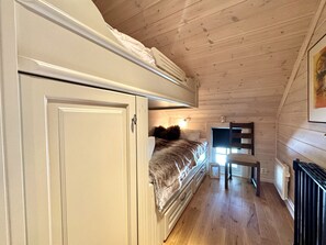 Una habitación pequeña con cama, una mesita y un armario.